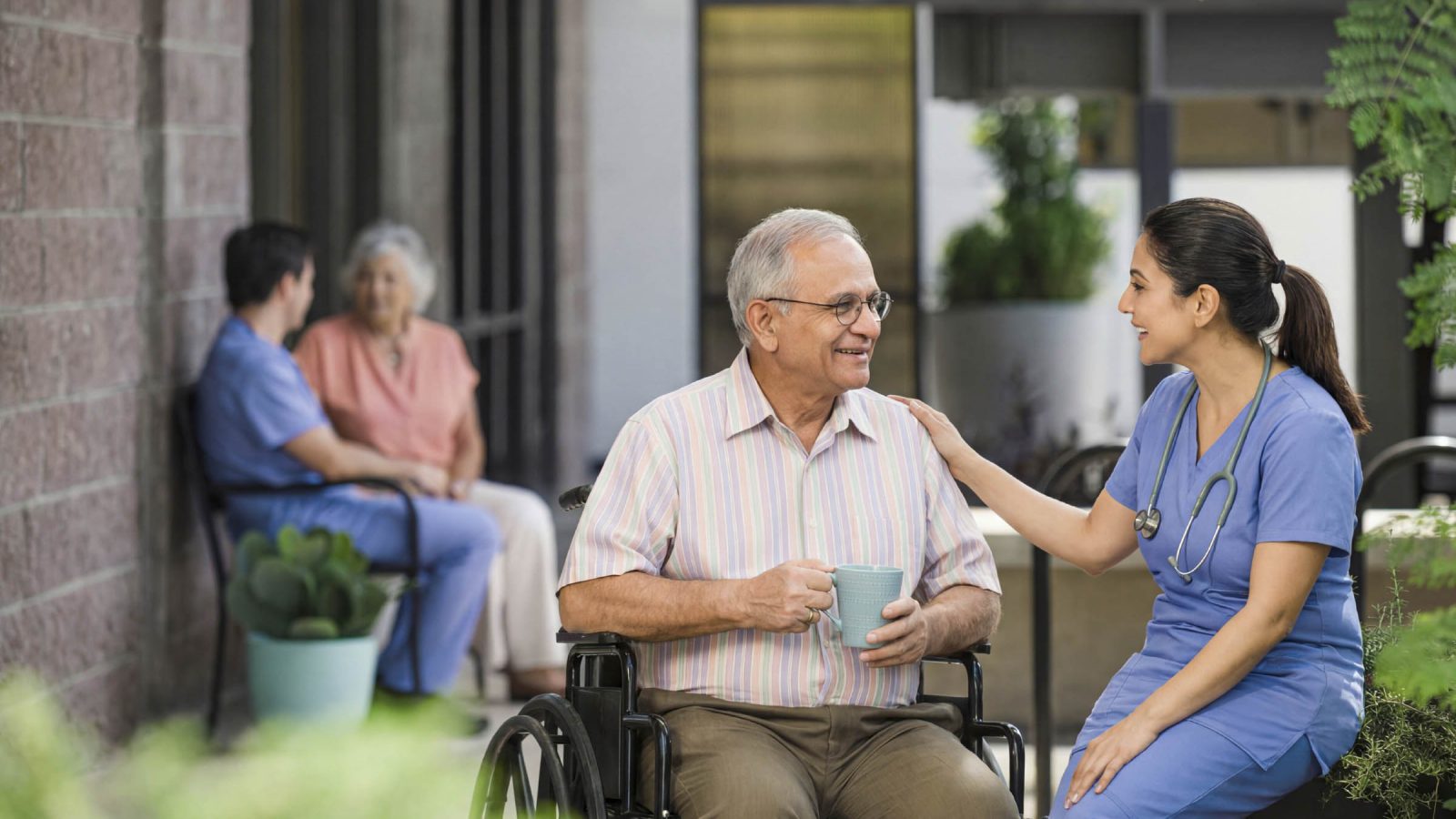 A caregiver sitting with a resident in the garden